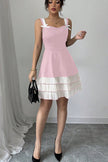 Pink FJØRNA summer party dress with a bow detail and pleated design, perfect for festive occasions.