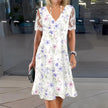 FJØRNA elegant floral midi dress for women with V-neck, flowing fabric, and stylish design perfect for casual or semi-formal wear.