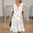 FJØRNA elegant floral midi dress for women with V-neck, flowing fabric and a stylish, feminine design perfect for special occasions.