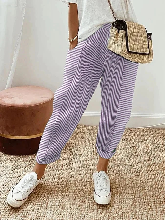 FJØRNA Holly™ striped purple pants with a relaxed fit and bold pattern, showcased on a model against a neutral background.