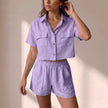 FJØRNA relaxed purple two-piece shorts set with collared top and matching shorts in lightweight textured woven fabric.