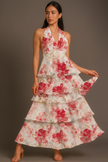 Red FJØRNA floral halter tiered ruffle maxi dress with waist detail, featuring a vibrant floral print and flowing silhouette.