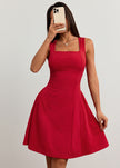 FJØRNA red flared fit summer dress with square neckline, mini length, shown in mirror selfie on a white background.