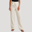 FJØRNA Reyna women's drawstring wide-leg pants with relaxed fit and lightweight fabric, shown hanging on a clothing rack.