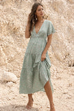 Sage green floral print dress by FJØRNA featuring a flowy design and vibrant floral pattern, perfect for casual or semi-formal occasions.