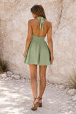 Sage green short skater dress by FJØRNA, featuring a fitted bodice and flared skirt, displayed on a hanger.