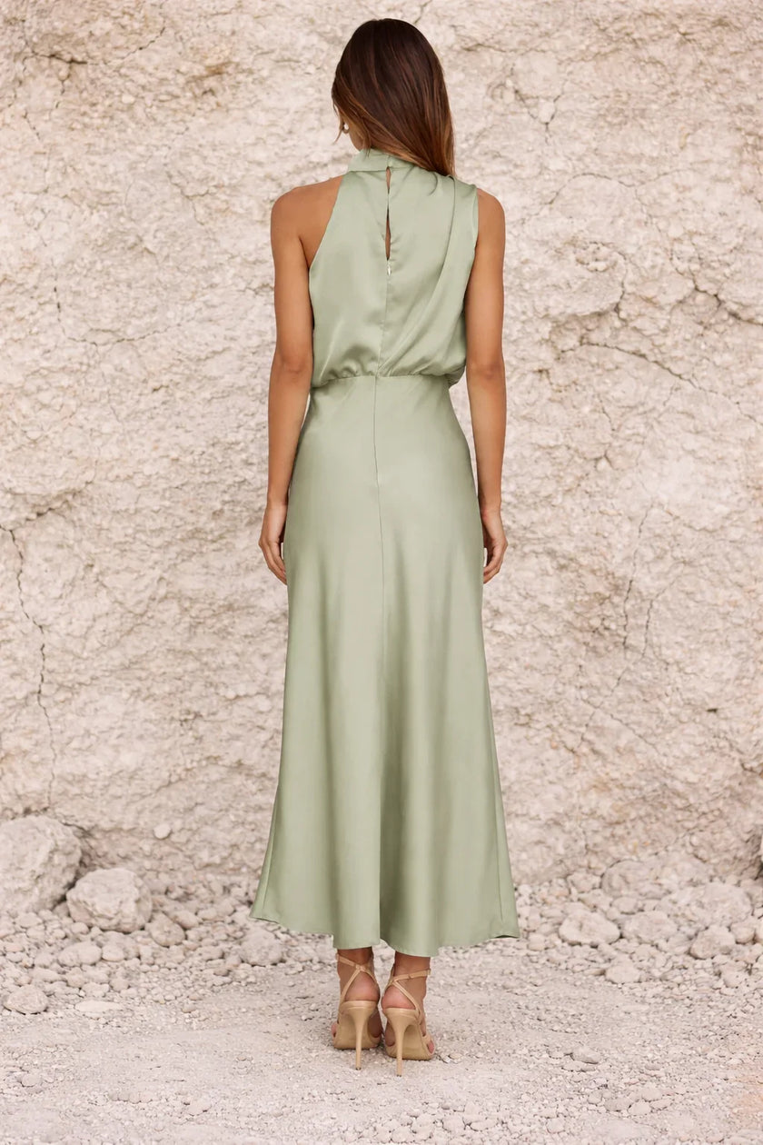 FJØRNA sage green satin dress with elegant fit and flowy fabric, suitable for formal or evening occasions.