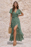 Dark sage green FJØRNA dress with long sleeves and a flowing silhouette, shown on a hanger against a neutral background.