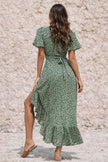 Dark sage green FJØRNA dress displayed on a mannequin, featuring a flowing silhouette and elegant design.