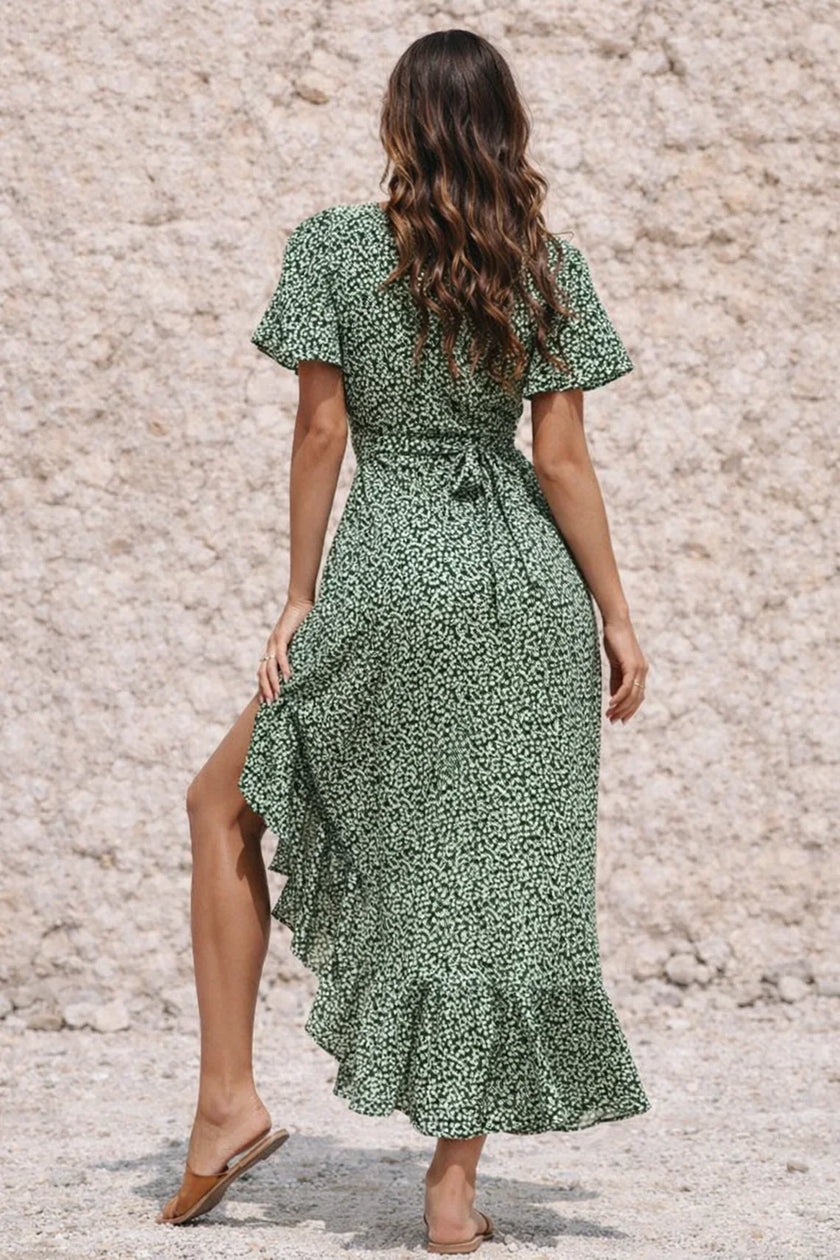 Dark sage green FJØRNA dress displayed on a mannequin, featuring a flowing silhouette and elegant design.