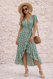 FJØRNA sage green wrap dress with a slit, featuring a flowy design and elegant neckline, perfect for stylish occasions.