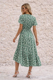 Sage green wrap dress with slit by FJØRNA, featuring a stylish V-neck and flowing fabric perfect for elegant occasions.
