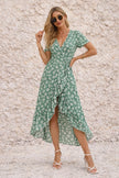 Sage green FJØRNA wrap dress with a slit, featuring a flattering neckline and flowing fabric, styled for elegant occasions.