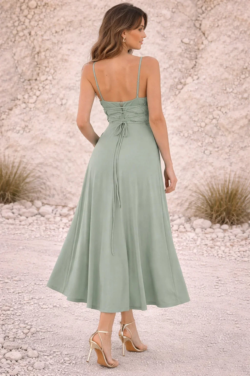 Dusty sage green FJØRNA dress with a flowing design, featuring soft fabric and elegant silhouette in the image.