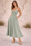 Dusty sage green FJØRNA dress featuring a flowing design and soft fabric, perfect for casual or semi-formal wear.