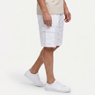 Men's linen cargo shorts with drawstring waist by FJØRNA, shown from the side, featuring multiple cargo pockets and a relaxed fit.