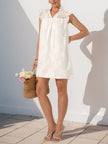 Side view of a white lace FJØRNA casual summer wedding dress, featuring delicate fabric and elegant design for summer occasions.