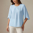 Sky blue pleated summer blouse for women from FJØRNA, casual top with lightweight fabric and stylish design.