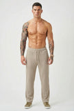FJØRNA relaxed knit khaki trousers displayed on a model, showcasing comfortable, casual style and soft fabric.