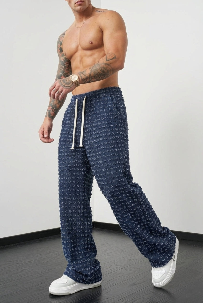 Black distressed trousers by FJØRNA with a relaxed fit, shown on a model with a casual, trendy style.