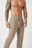 Beige merino wool trousers by FJØRNA, featuring a tailored fit and soft fabric, displayed on a model.