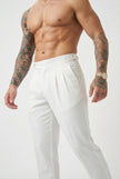 White tailored trousers by FJØRNA, shown on a model, featuring a sleek fit and classic design for versatile styling.