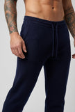 FJØRNA navy merino wool trousers displayed on a model, showcasing their tailored fit and soft fabric for casual or professional wear.