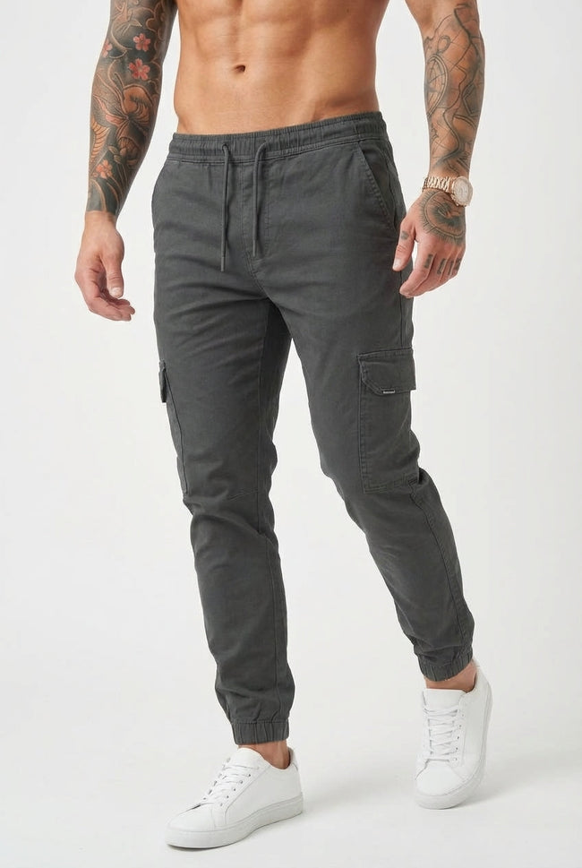 Men's grey cargo jogger trousers by FJØRNA, featuring a relaxed fit and multiple pockets, shown on a model.
