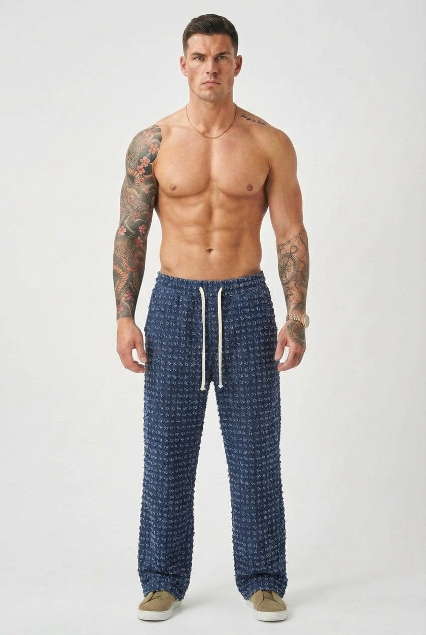 FJØRNA black distressed trousers with a relaxed fit, featuring ripped details and casual style, displayed on a neutral background.