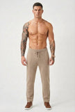 FJØRNA beige merino wool trousers, stylish and comfortable, shown on a model with a relaxed fit and clean design.
