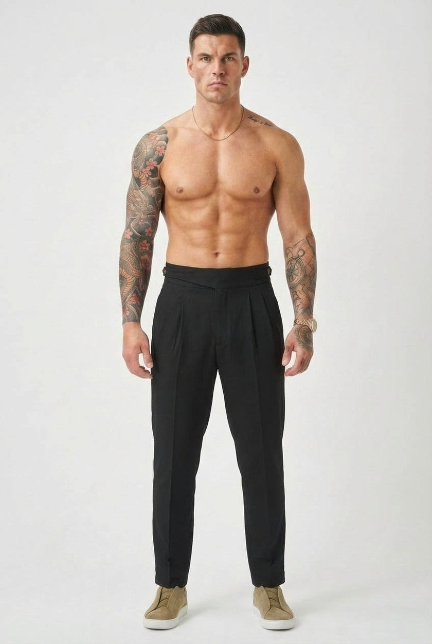 Black tailored trousers by FJØRNAs, featuring a slim fit and classic design, displayed on a model.