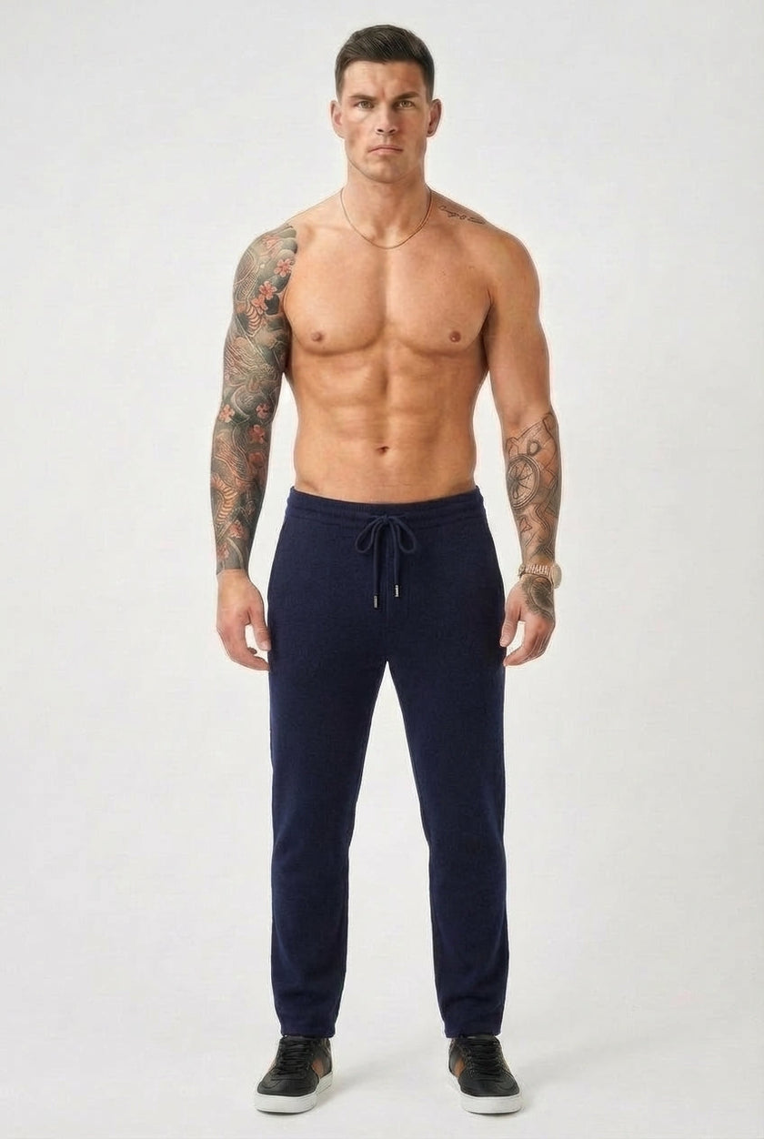 FJØRNA navy merino wool trousers laid flat, showing the tailored fit and soft fabric texture.