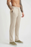 FJØRNA relaxed knit trousers in khaki worn by a model, showcasing a comfortable, casual fit with a soft knit fabric.
