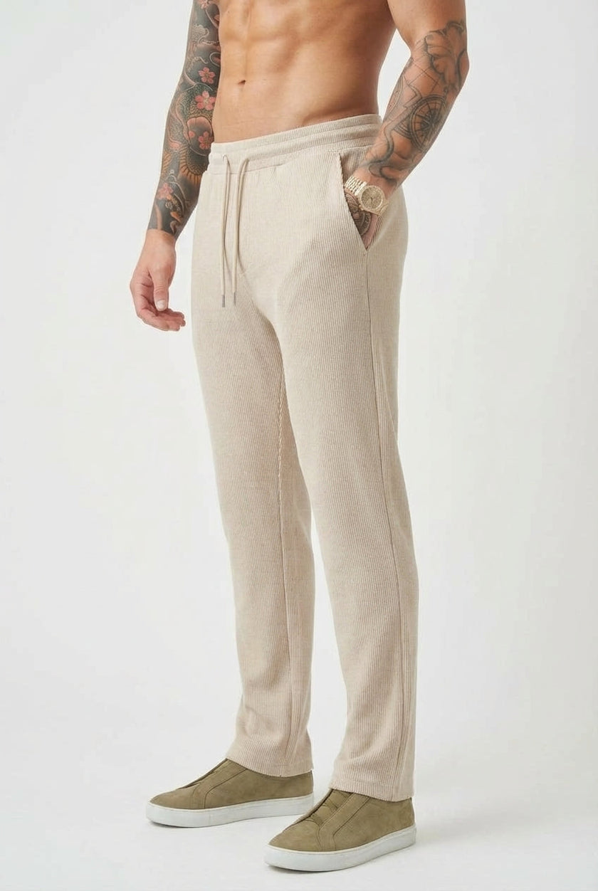 FJØRNA relaxed knit khaki trousers displayed on a model, featuring a casual fit and soft knit fabric for comfortable wear.