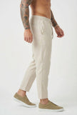 FJØRNA cropped linen trousers in indigo, showcasing a relaxed fit and lightweight fabric on a model.