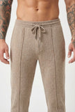 Beige merino wool trousers by FJØRNA displayed on a model, highlighting the soft fabric and tailored fit.