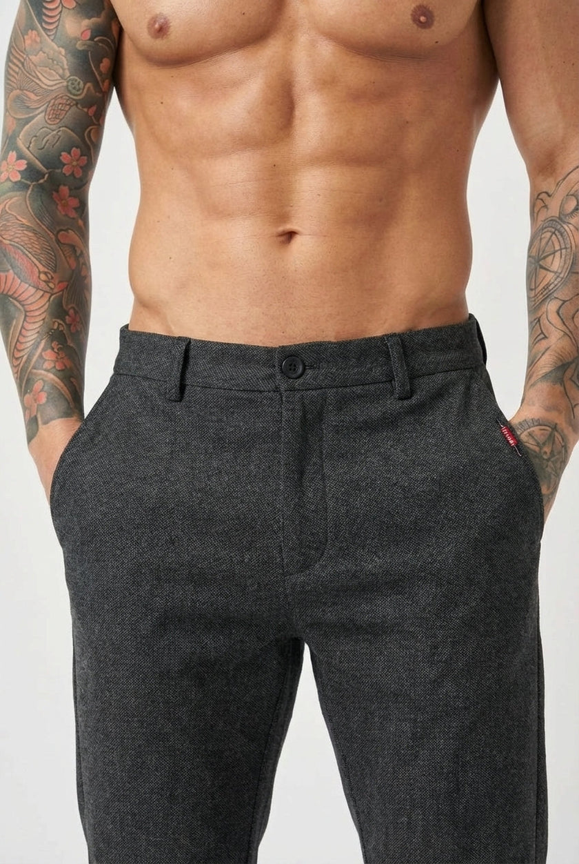 Black slim-fit trousers by FJØRNA, displayed on a model, showcasing a tailored, modern fit and sleek design.