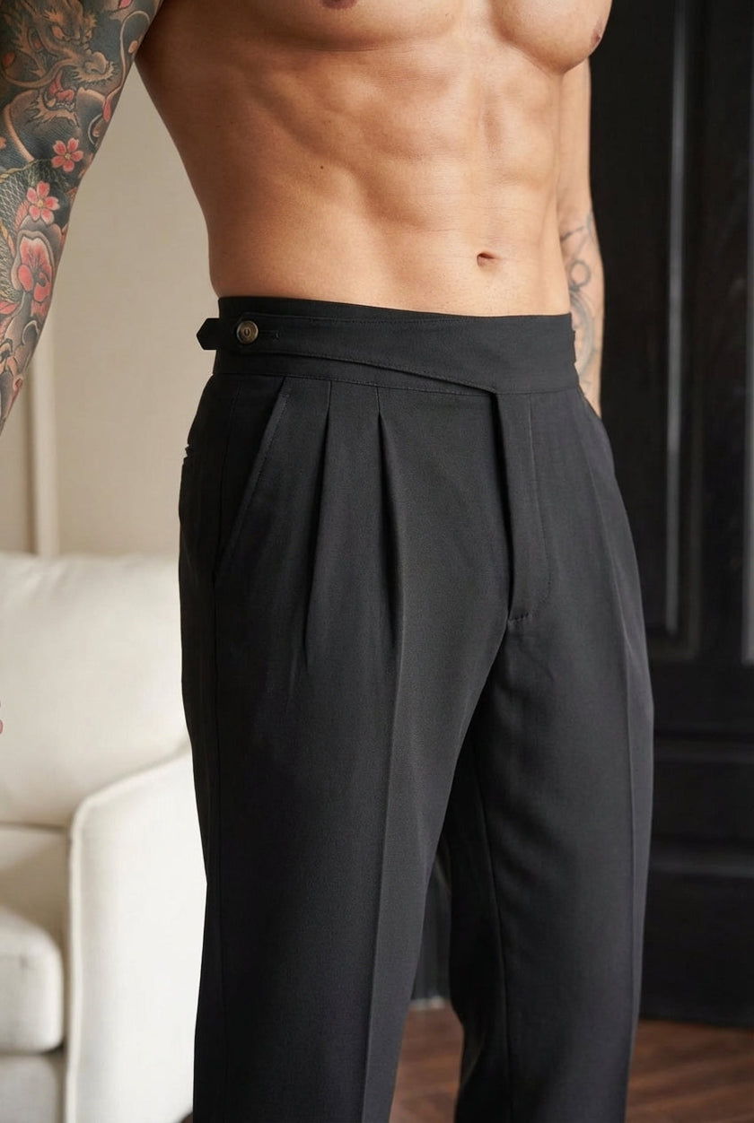 FJØRNA tailored black trousers featuring a slim fit design, shown on a model with a classic waistband and sleek silhouette.
