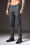FJØRNA slim-fit light grey trousers displayed on a mannequin, showcasing modern tailored design and clean lines.