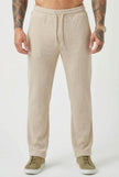 FJØRNA relaxed khaki knit trousers displayed on a model, showcasing casual, comfortable fit and soft fabric details.
