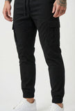 Black FJØRNA cargo jogger trousers displayed on a model, showcasing the relaxed fit and functional pockets.