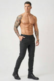 Black slim-fit trousers by FJØRNA, shown on a model, with a tailored fit and modern design for versatile styling.