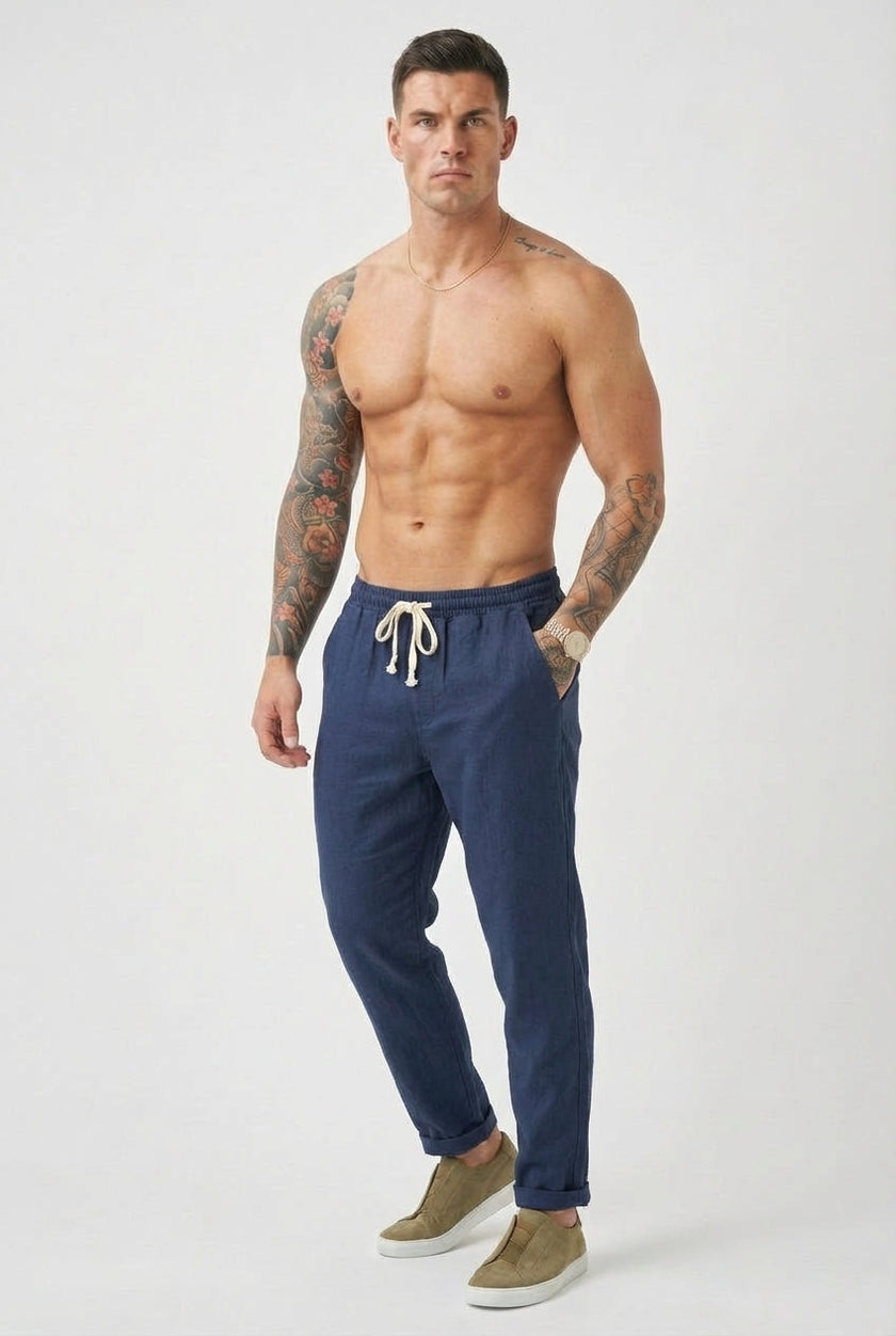 FJØRNA linen tailored trousers in neutral color, featuring a sleek fit and classic design, perfect for stylish casual wear.
