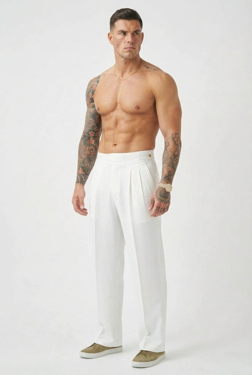 White tailored trousers by FJØRNA, featuring a sleek fit and classic design, shown on a model in a stylish indoor setting.