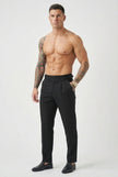 Black tailored trousers by FJØRNA, shown on a model, featuring a sleek fit and classic design suitable for professional or casual wear.