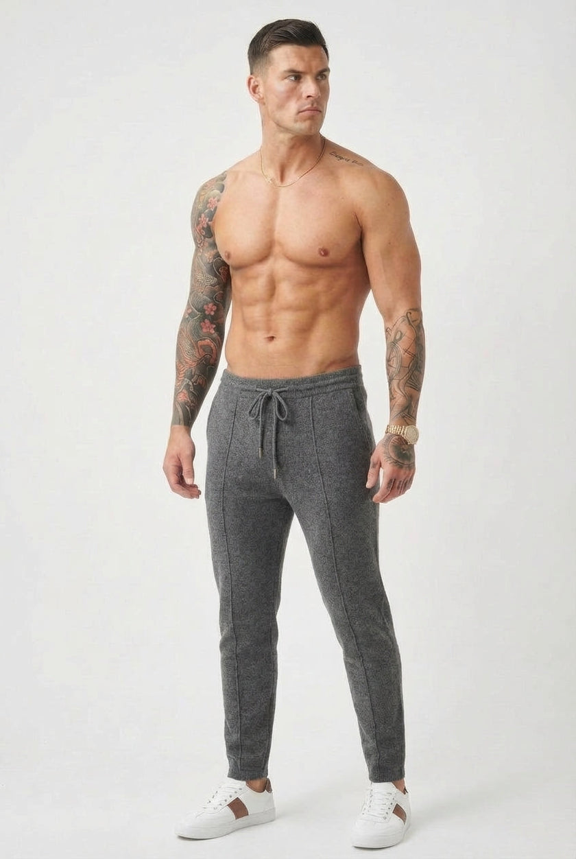 FJØRNA merino wool trousers in dark grey, featuring a tailored fit and classic style, shown on a model.