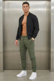 FJØRNA cargo jogger trousers in army green with multiple pockets and relaxed fit, displayed on a model.