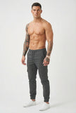 FJØRNA grey cargo jogger trousers displayed on a model, featuring multiple pockets and relaxed fit for casual wear.