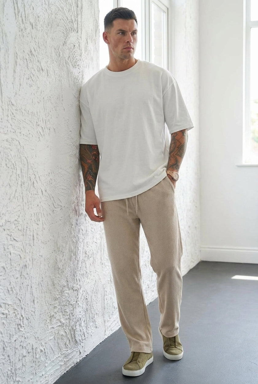 FJØRNA relaxed knit khaki trousers displayed on a hanger with a soft fabric texture and casual fit.