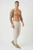 FJØRNA cropped linen trousers in indigo color, featuring a relaxed fit and lightweight fabric, styled with a casual top.